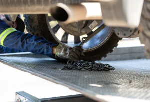 car being chained to flat bed tow turck